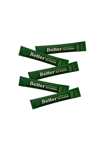Five green “Better caffeinated Greens” stick packets labeled strawberry pineapple on a white background