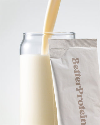 Protein shake being poured into a glass with a Better Protein package.