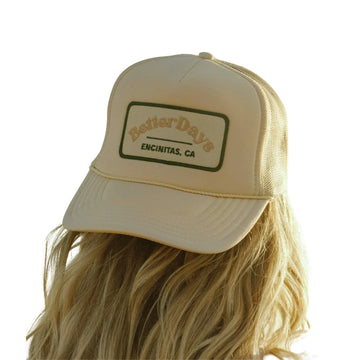 Beige trucker hat on a person with long blonde hair, patch reads “Better Days” and “Encinitas, CA”