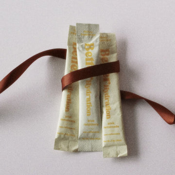 Three beige sachets tied with a brown ribbon on a light background.