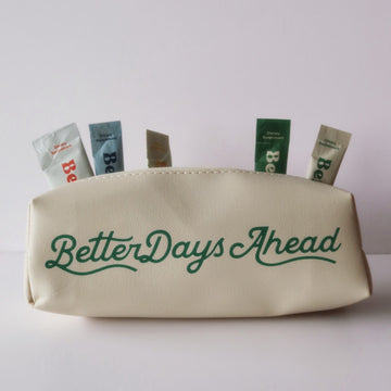 Beige pouch with green “BetterDaysAhead” text, with five supplement packets sticking out of the top.
