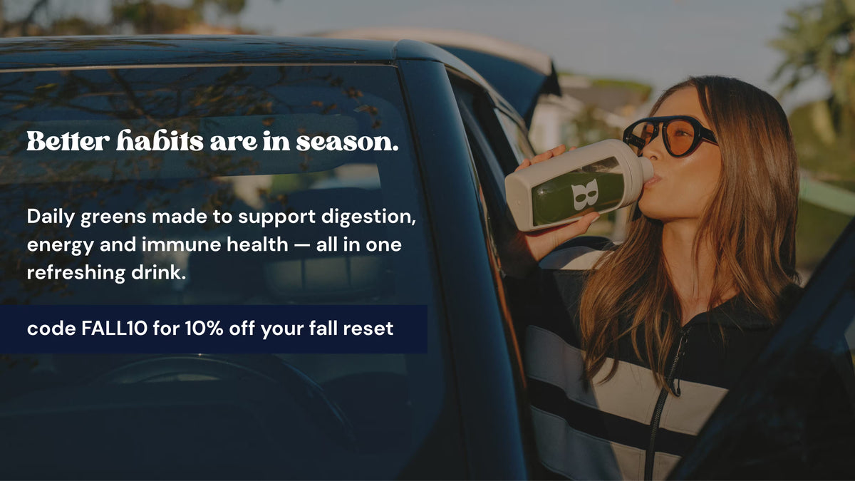 A woman in a car window drinking from a white bottle with green and black labeling. Promotional text on the left reads, 'Better habits are in season.