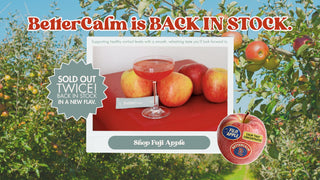 Promotional image for Fuji apples with a glass of juice and text about availability.