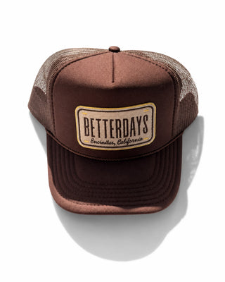 A brown trucker hat with a brown mesh back and a front patch reading 'BETTERDAYS Encino, California'.